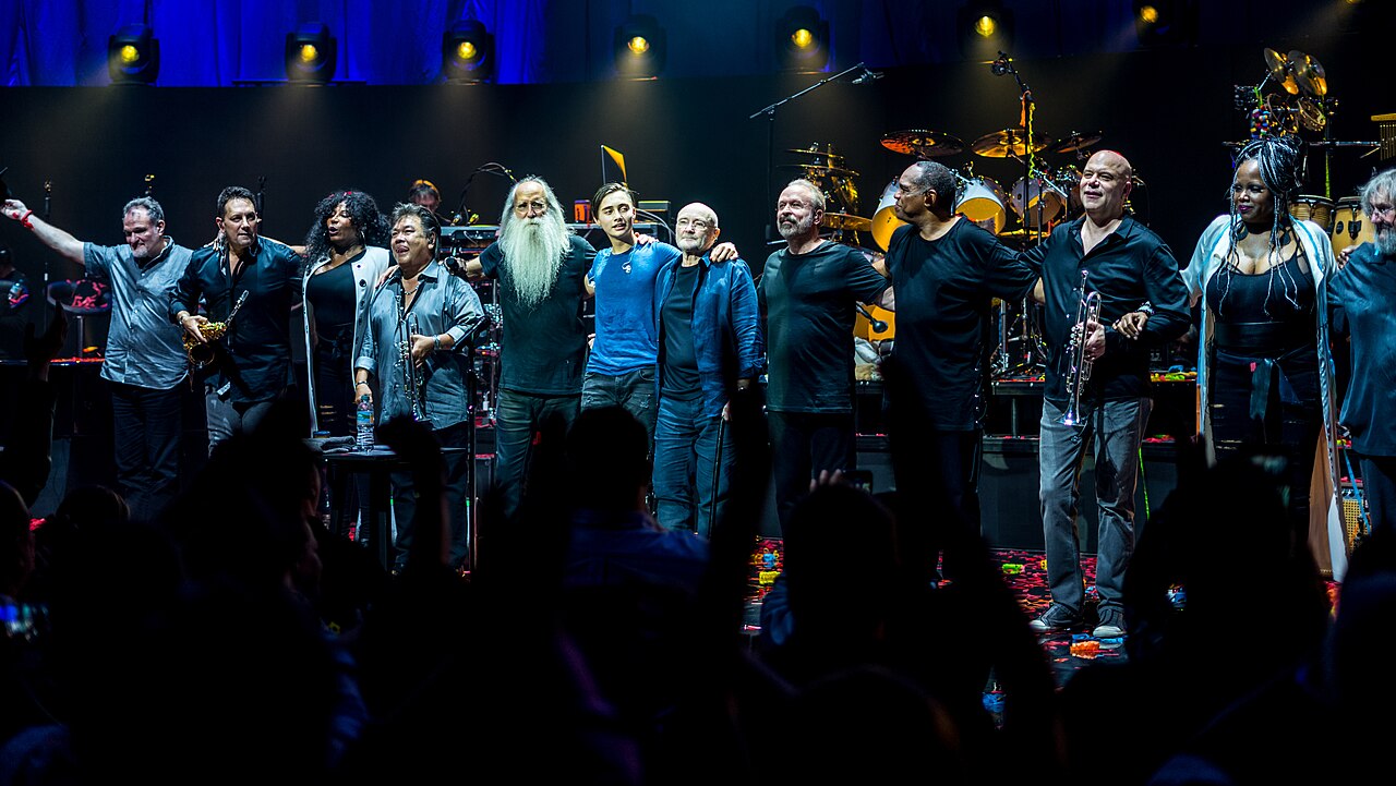 Phil Collins seated with mic at the Royal Albert Hall, 2017