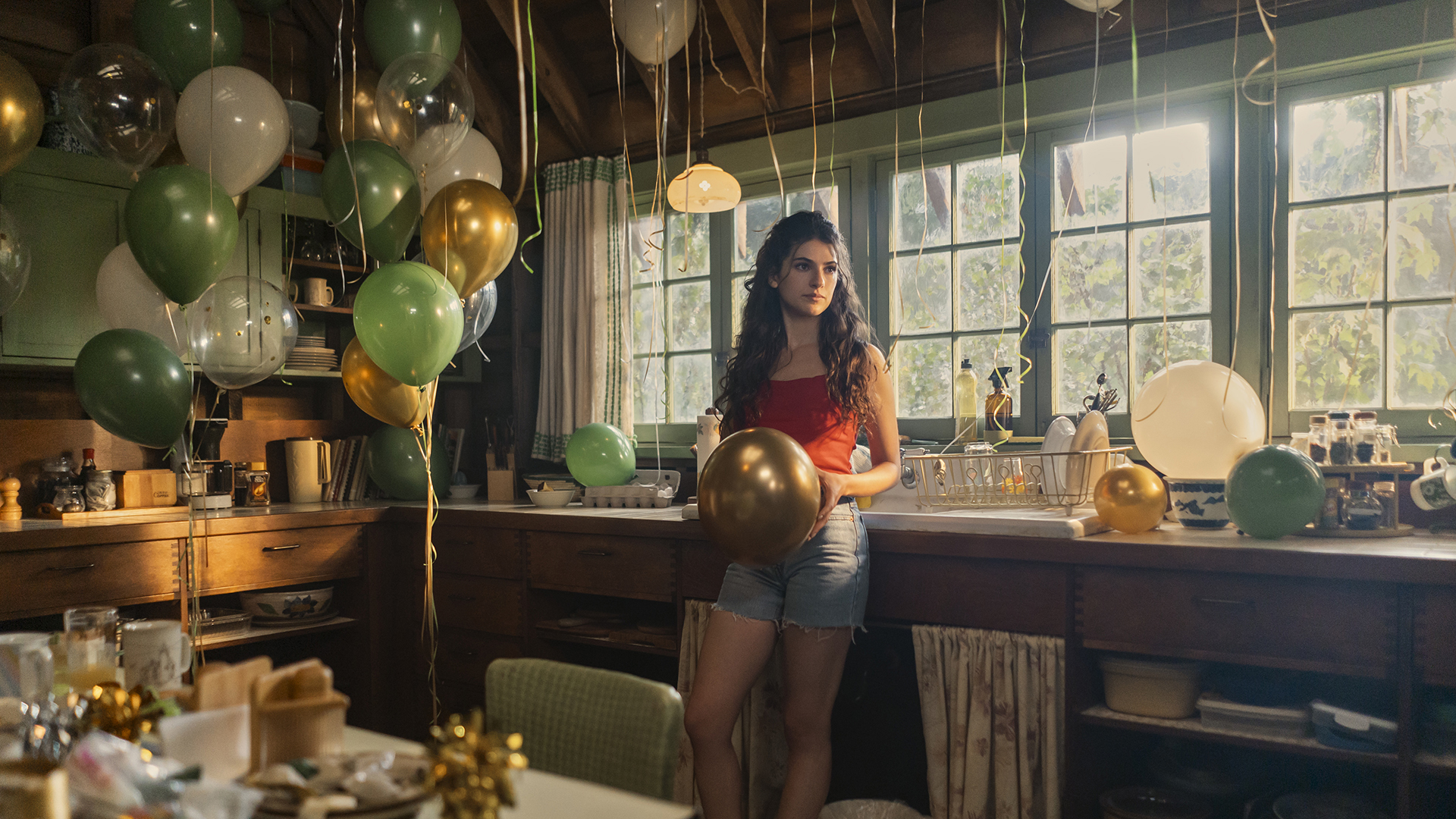 Annie amid birthday balloons in a cabin kitchen